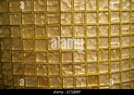 Texture à carreaux en verre doré ou motif géométrique abstrait en maille ou arrière-plan. Verre doré ou mosaïque smalt avec remplissage jaune des coutures Banque D'Images