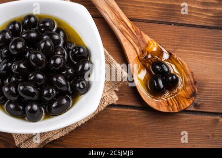 Olives noires sur table rustique de la région d'Apulia, Italie Banque D'Images