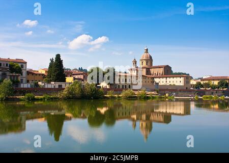 Se dressant sur les rives de l'Arno et regardant le reflet miroir de l'architecture de la Renaissance à Florence en Italie. Banque D'Images