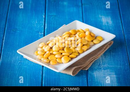 Lupini dans une assiette blanche sur une table rustique Banque D'Images