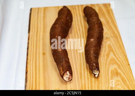 Yucca cru sur la table en bois, Manihot esculenta. (Tubercule brut de manioc). Manioc, également appelé mandica, yuca, balinghoy, mogo, mandica, kamoteng kahoy, Banque D'Images