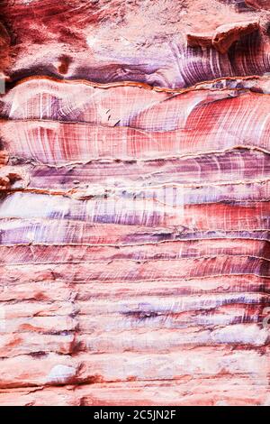 La surface rocheuse en grès rouge du canyon appelée Al Siq à l'entrée de la ville rose de Petra en Jordanie. Banque D'Images