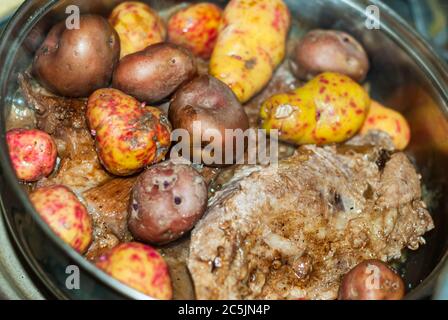 Steaks de bœuf cuits dans la poêle avec des oignons, des pommes de terre andines, des herbes fines et des épices. Banque D'Images