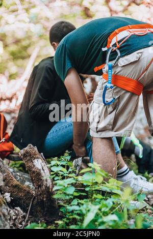 Grimpeur mural en pierre portant un harnais de sécurité et un équipement d'escalade Banque D'Images