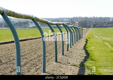 Un petit foyer de clôtures tubulaires légères vues sur une piste de course professionnelle. La piste souple a été mise en rack depuis la dernière course. Banque D'Images