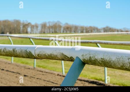 Un petit foyer de clôtures tubulaires légères vues sur une piste de course professionnelle. La piste souple a été mise en rack depuis la dernière course. Banque D'Images