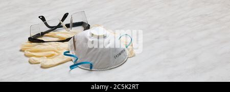 Masque blanc FFP2, N95 avec lunettes et gants en latex sur une table blanche. Banque D'Images