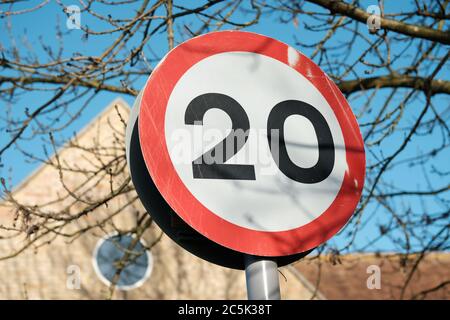 Vue détaillée d'un panneau de limite de vitesse de la route britannique de 20 km/h vu près d'un centre-ville. La faible vitesse est due à des zones résidentielles et à de nombreux piétons. Banque D'Images