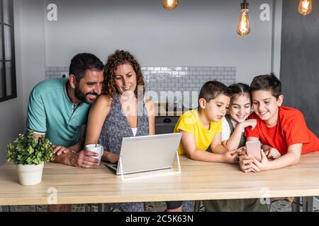 Une famille nombreuse et heureuse, connectée à la technologie Banque D'Images