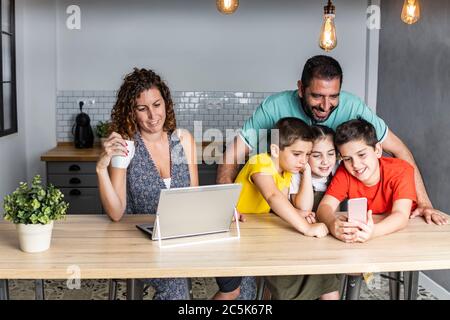 Une famille nombreuse et heureuse, connectée à la technologie Banque D'Images