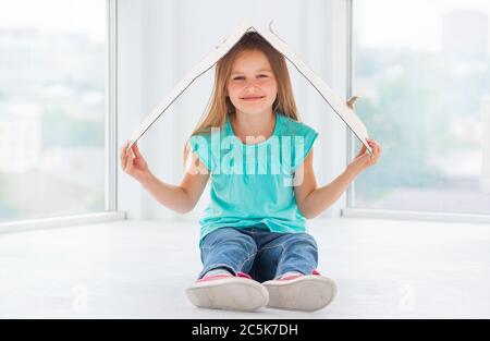 Beatiful Kid Girl est drôle couvrant sa tête avec un morceau de carton Banque D'Images