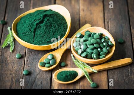 Comprimés de spiruline et poudre dans des bols Banque D'Images