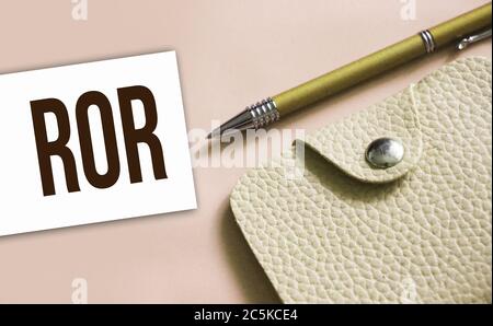 Abréviation de ROR inscrite sur une carte de visite, un stylo et un portefeuille en cuir beige. Concept d'affaires financières Banque D'Images