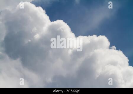 Les nuages Cumulus s'construisent dans un ciel bleu foncé avant une tempête de pluie. Banque D'Images