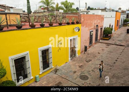 Une femme descend une allée colorée dans l'ancienne section coloniale de Santiago de Queretaro, État de Queretaro, Mexique. Banque D'Images