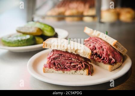 Sandwich pastrami avec un côté de cornichons servi dans un déli juif Banque D'Images