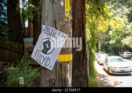 Un panneau protestant contre le meurtre de George Floyd est accroché à un poteau dans un quartier de Mill Valley, CA. Banque D'Images