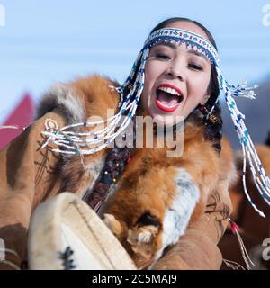 Femme en vêtements nationaux habitants autochtones Kamchatka dansant avec tambourine. Concert, célébration fête nationale de Koryak Journée de Seal Hololo Banque D'Images