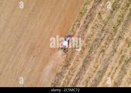 vue aérienne par drone d'un tracteur labourant dans un champ Banque D'Images