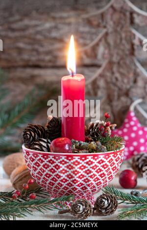 décoration de noël avec bougies rouges et cônes dans une tasse Banque D'Images