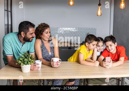 Une famille nombreuse et heureuse, connectée à la technologie Banque D'Images