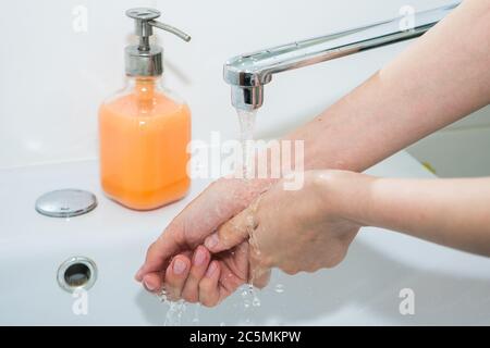 Lavage des mains avec du savon. Elle se lave les mains avec du savon antibactérien Banque D'Images