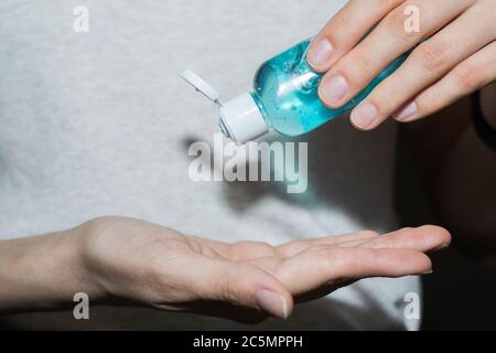 Assainisseur antiseptique dans les mains. Elle traite ses mains avec un agent antibactérien. Banque D'Images