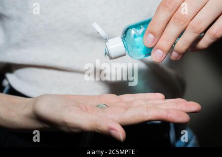 Assainisseur antiseptique dans les mains. Elle traite ses mains avec un agent antibactérien. Banque D'Images