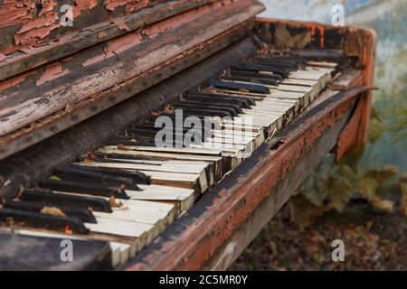 Un vieux piano cassé dans la rue avec une grande poêle avec des touches blanches et noires. Banque D'Images