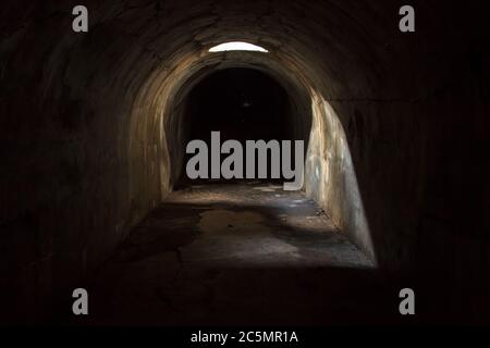 Un passage souterrain sombre et effrayant avec une lucarne au plafond, dans un couloir sombre, au fort de Pospelov sur l'île russe de Vlad Banque D'Images