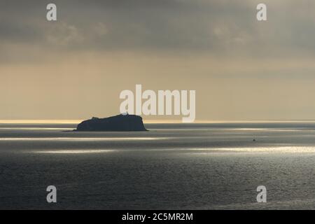 L'île de Skrypleva, où se trouve le plus vieux phare de Vladivostok, est éclairée par le soleil qui se brise à travers les nuages. Banque D'Images