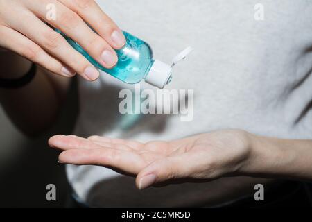 Assainisseur antiseptique dans les mains. Elle traite ses mains avec un agent antibactérien. Banque D'Images