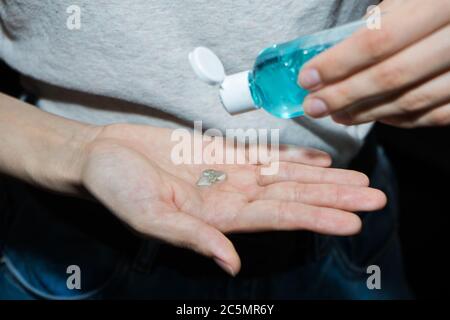 Assainisseur antiseptique dans les mains. Elle traite ses mains avec un agent antibactérien. Banque D'Images