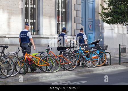 Bruxelles, Belgique - juillet 03 2019 : trois policiers portant un gilet pare-balles patrouillent dans la rue. Banque D'Images