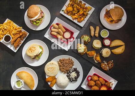 Table avec cuisine latino-américaine, arepa, tequeños, pabellón, cachapas. Vue d'en haut. Banque D'Images