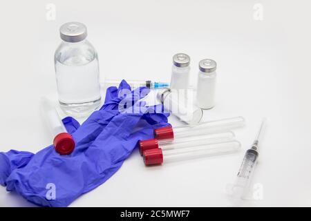 Sur la table se trouvent les articles médicaux et la seringue d'injection, les tubes à essai vides. Concept de médecine sur fond blanc Banque D'Images