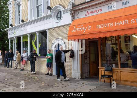 Chiswick, Londres, Royaume-Uni. 4 juillet 2020. Les hommes font la queue pour une coupe de cheveux alors que les barbiers en Angleterre ouvrent pour la première fois depuis le verrouillage du coronavirus. Crédit : Andy Sillett/Alay Live News Banque D'Images