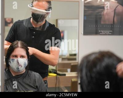 Sheffield, Royaume-Uni. 4 juillet 2020. Conrad Blandford, propriétaire du salon de coiffure Conrad Blandford, Sheffield porte un équipement de protection individuelle (EPI) et un masque de protection lors de la réouverture des salons de coiffure à travers le Royaume-Uni. Le propriétaire du salon de coiffure Conrad Blandford a mis aux enchères leur premier poste de fermeture à cheveux, élevant un montant stupéfiant de 180 £ à donner au NHS dans le cadre de leurs 72e anniversaire. Credit: Ioannis Alexopoulos/Alay Live News Banque D'Images