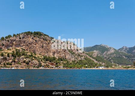 Vue de la mer sur un village touristique sur le fond d'une montagne brune Banque D'Images