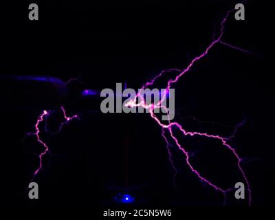 Décharges électriques de bleu et de violet dans l'obscurité. Flou, flou artistique Banque D'Images