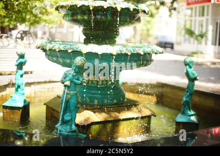 Fontaine avec statues de garçons versant de l'eau des vaisseaux Banque D'Images