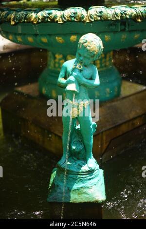 Fontaine avec statue en marbre vert d'ange versant de l'eau de la carafe. Banque D'Images