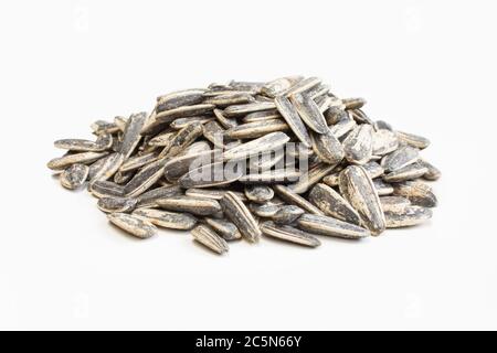 Graines de tournesol salées et rôties en carapace isolée sur fond blanc Banque D'Images