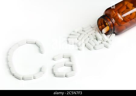 Vue de dessus des comprimés de calcium blanc qui s'injectent dans une bouteille de verre. Supplément de calcium comprimés formant la forme CA sur fond blanc. Banque D'Images