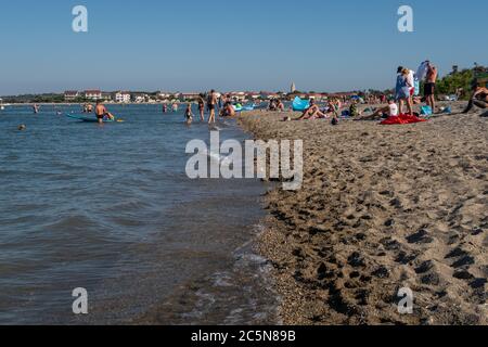 Les gens apprécient la mer peu profonde à Queen's Beach avec la petite ville historique de Nin en arrière-plan, le comté de Zadar, Dalmatie, Croatie Banque D'Images