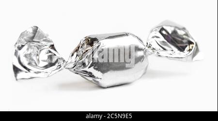Bonbons en papier d'emballage brillant gris isolé sur fond blanc. Modèle noir et blanc Banque D'Images