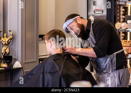 Harrogate, North Yorkshire, Royaume-Uni. 4 juillet 2020. Hugo Wragg, du salon de coiffure Steca N.6, au travail, portant des EPI complets tandis que les barbiers rouvrent au public le Super Saturday. Crédit: ernesto rogata/Alay Live News Banque D'Images