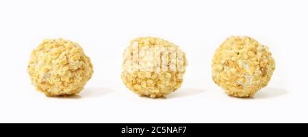 Boules de chocolat blanc sucrées isolées sur fond blanc. Friandises jaunes avec garniture Banque D'Images