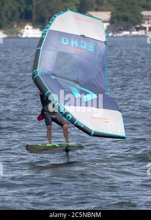 Berlin, Allemagne. 04e juillet 2020. Un surfeur à ailes fait le tour des vagues du Tegeler See. Le surf sur les ailes offre une combinaison de planche à voile et de kite. Crédit : Paul Zinken/dpa/Alay Live News Banque D'Images