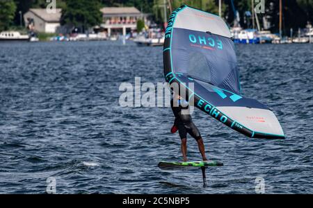 Berlin, Allemagne. 04e juillet 2020. Un surfeur à ailes fait le tour des vagues du Tegeler See. Le surf sur les ailes offre une combinaison de planche à voile et de kite. Crédit : Paul Zinken/dpa/Alay Live News Banque D'Images